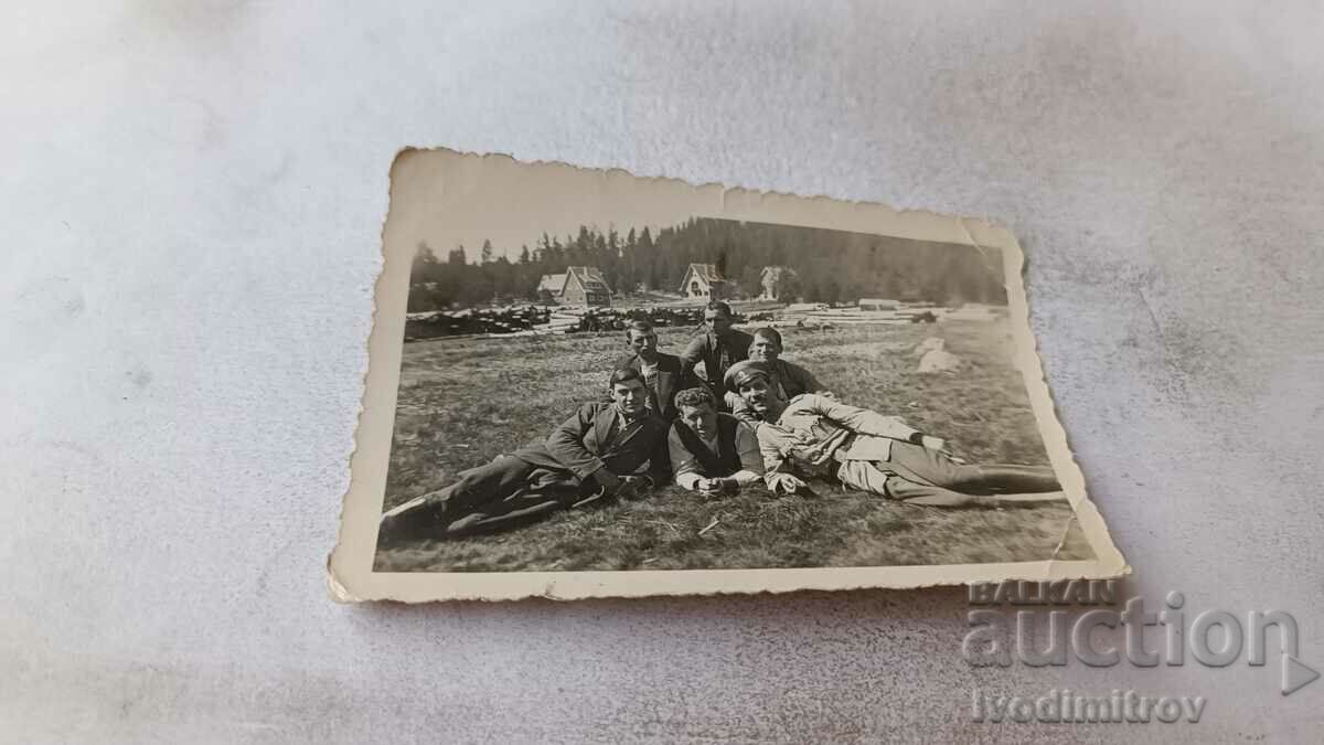 Αξιωματικοί φωτογραφιών και νεαροί άνδρες ξαπλωμένοι στο γρασίδι