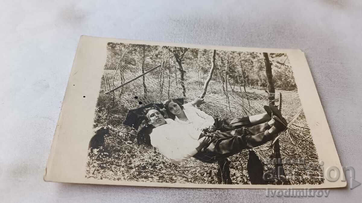 Fotografie Un tânăr și o fată pe un hamac în curte