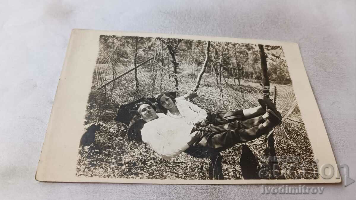Photo A young man and a girl on a hammock in the yard