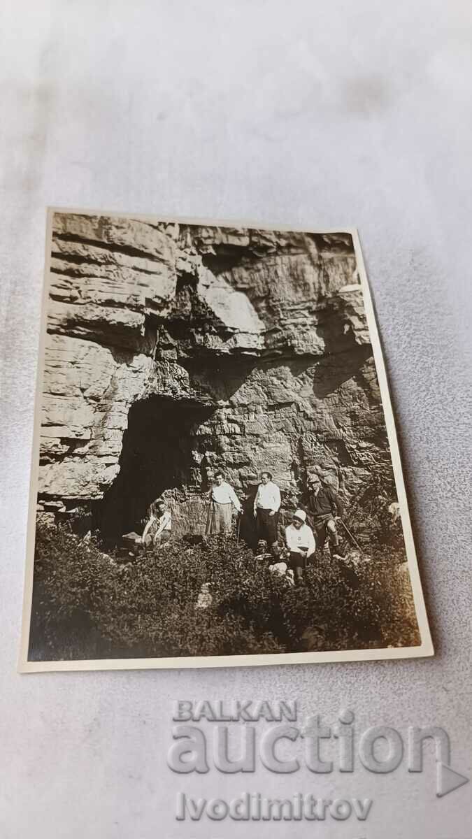 Foto Bărbați și femei în fața intrării într-o peșteră
