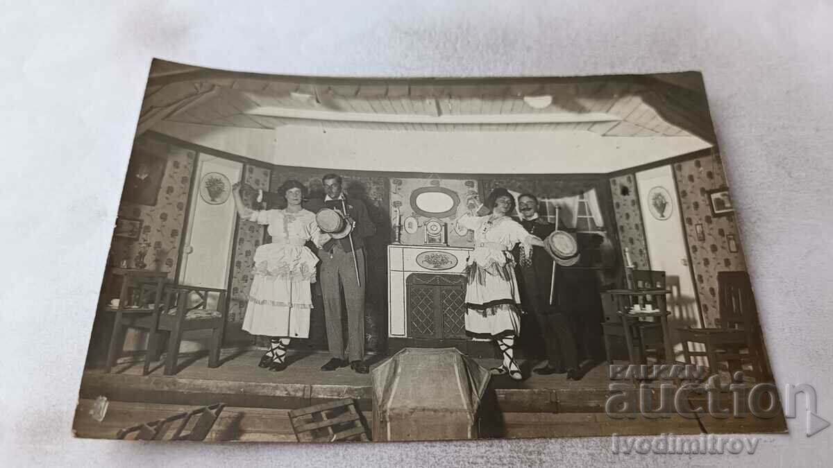 Foto Doi bărbați și două femei în costume de carnaval pe scenă