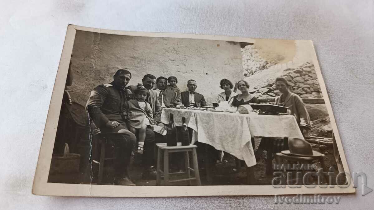 Αξιωματικός φωτογραφίας άνδρες γυναίκες και παιδιά σε ένα τραπέζι