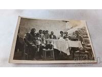 Αξιωματικός φωτογραφίας άνδρες γυναίκες και παιδιά σε ένα τραπέζι
