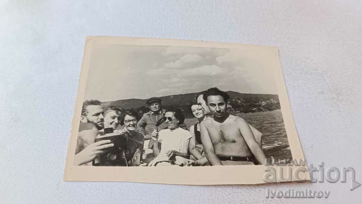 Снимка Жени и мъже голи до кръста на лодка в морето