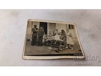 Снимка Мъже жени и деца ядат диня в двора на къщата си
