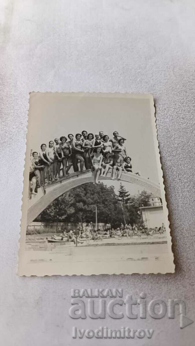 Fotografie Bărbați tineri și fete tinere în costume de baie pe un pod