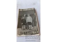 Foto Baie Femeie și doi băieți pe scaune de lemn 1930