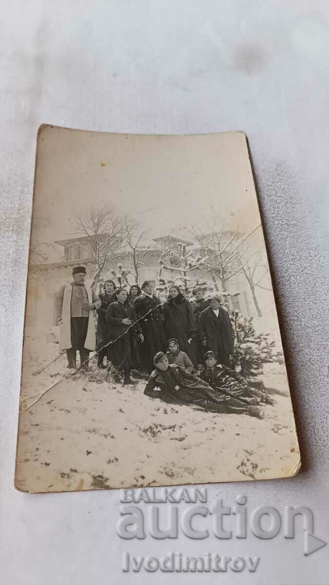 Photo Men, women and children in front of a house in winter