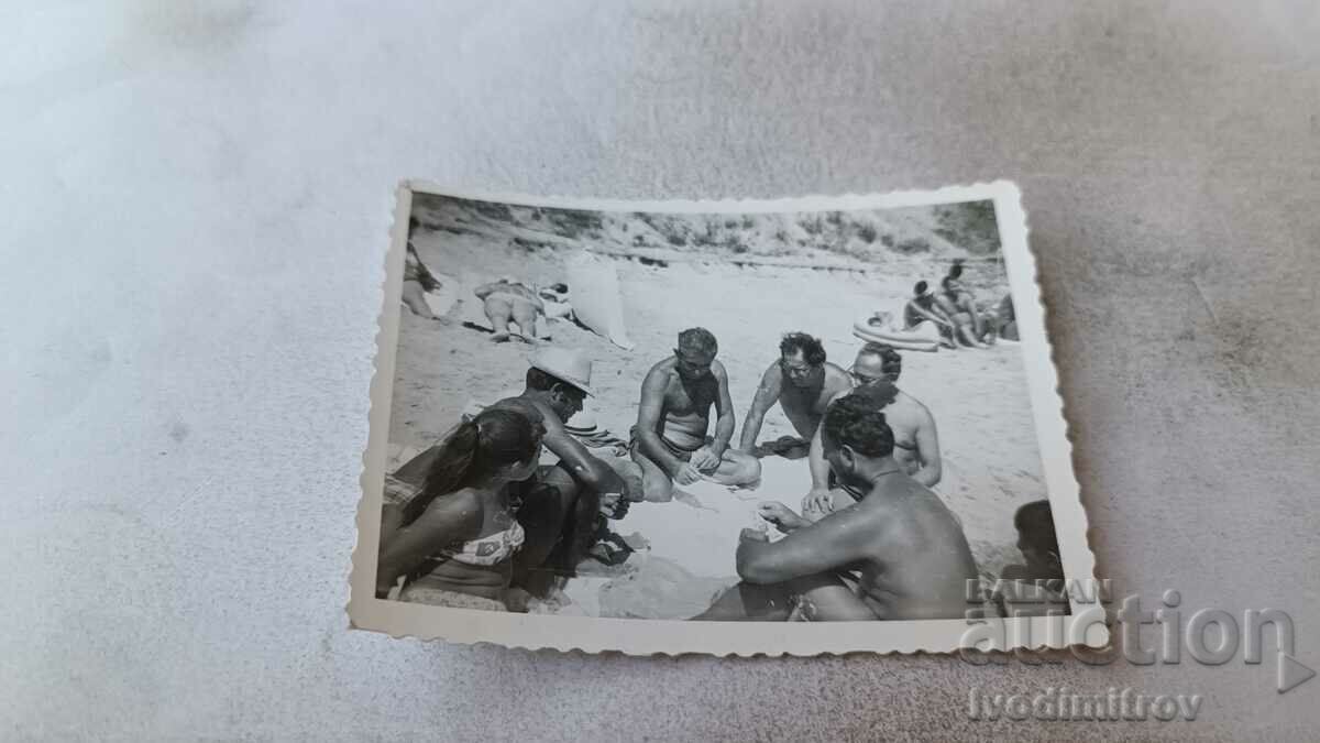 Φωτογραφία Άνδρες που παίζουν χαρτιά στην παραλία