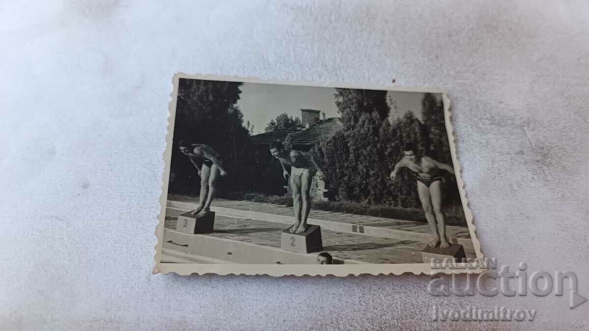 Φωτογραφία Τρεις νεαροί άνδρες έτοιμοι να πηδήξουν σε μια πισίνα