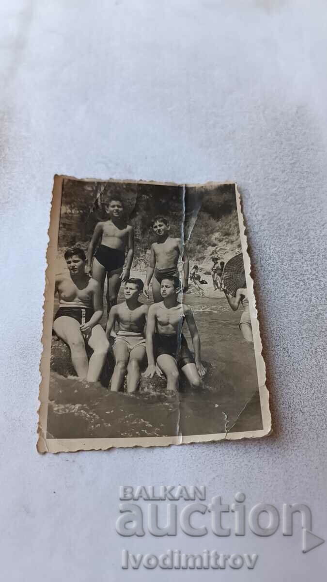 Photo Boys in swimsuits on a rock in the sea