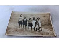 Photo A man, two women and three children on the beach