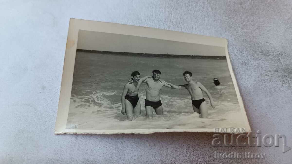 Foto Trei tineri pe plajă