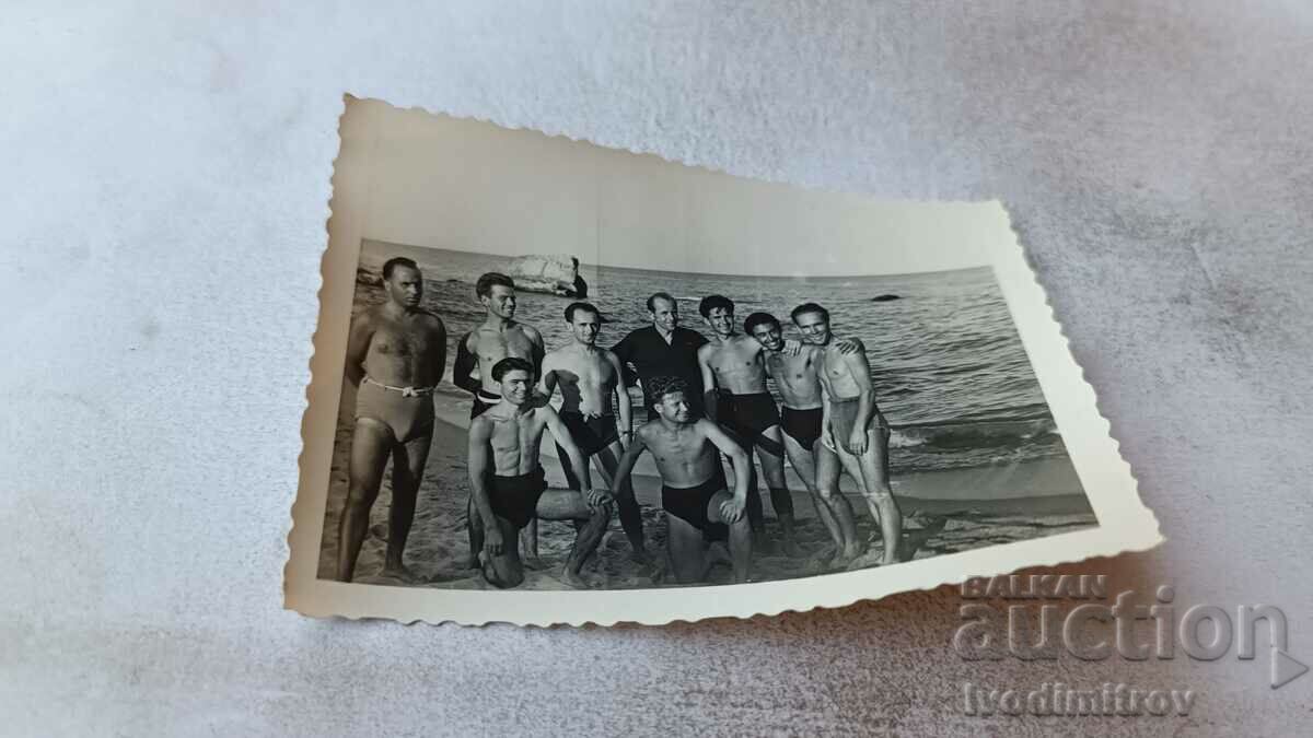 Fotografie Bărbați tineri în costume de baie pe plajă
