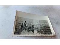 Fotografie Tineri în costume de baie pe o stâncă în mare