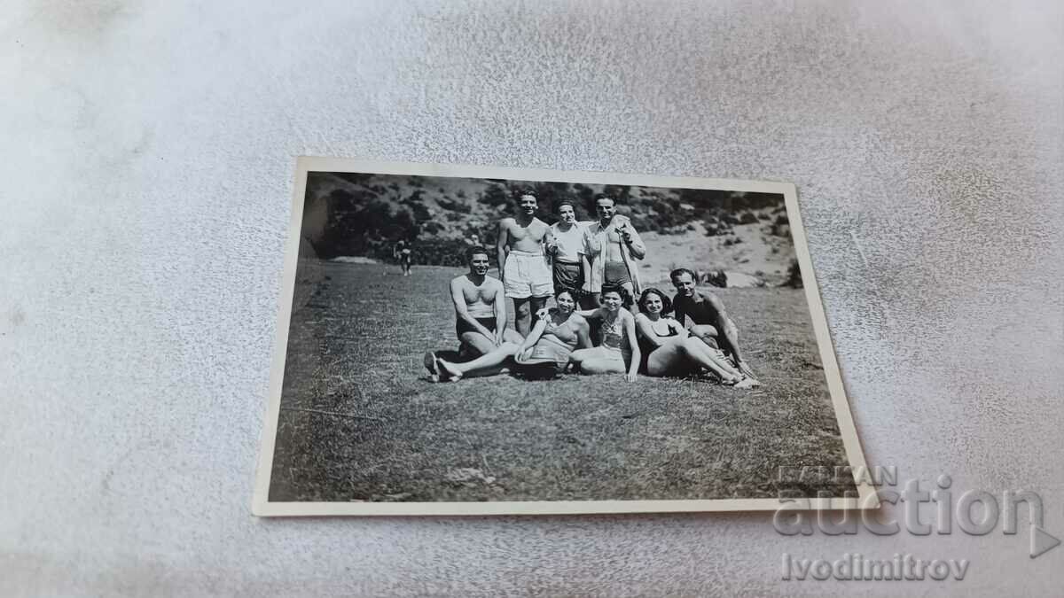 Photo Young men and women in swimsuits on the lawn