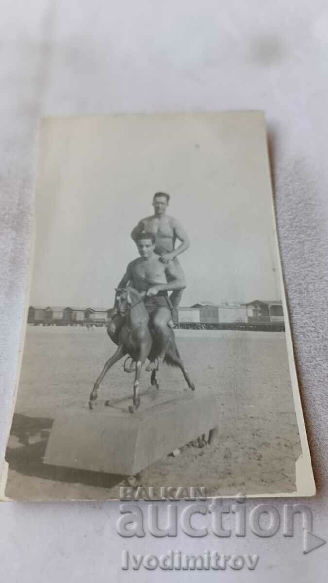 Φωτογραφία Δύο ερμηνευτές τσίρκου γυμνοί μέχρι τη μέση πάνω σε ένα μοντέλο αλόγου