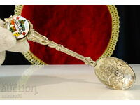 Silver plated spoon with embossed coat of arms.