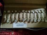 Collection of silver spoons with floral motifs.