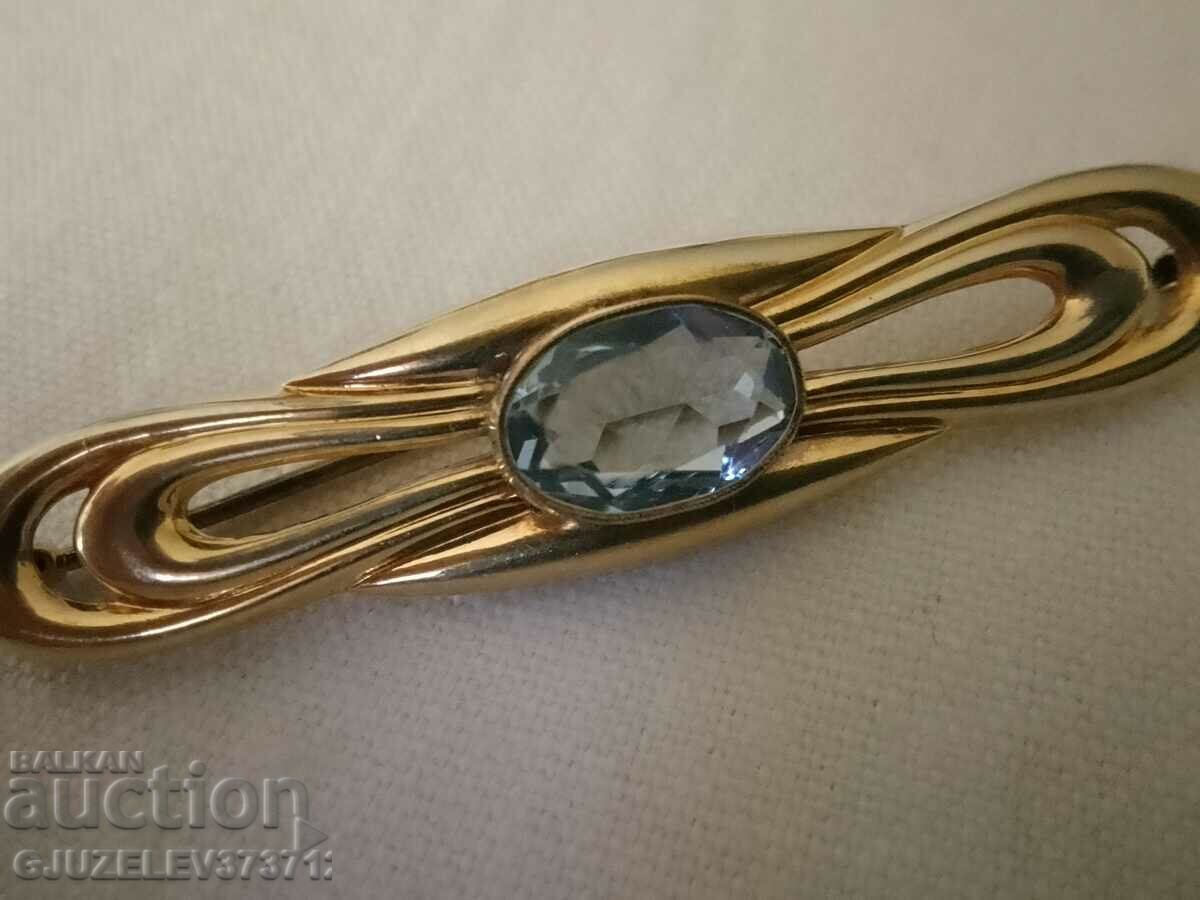 O broșă veche - cu o bijuterie mare albastră - marcată pe și