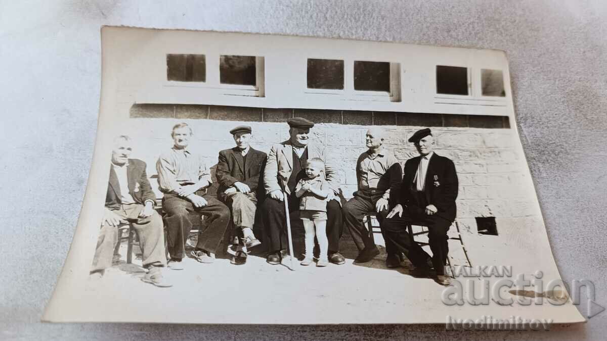 Picture Men sitting on chairs and a little boy
