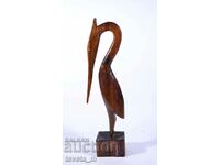 figură înaltă din lemn a unei păsări, lucrată manual