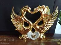 a golden statuette of a pair of swans