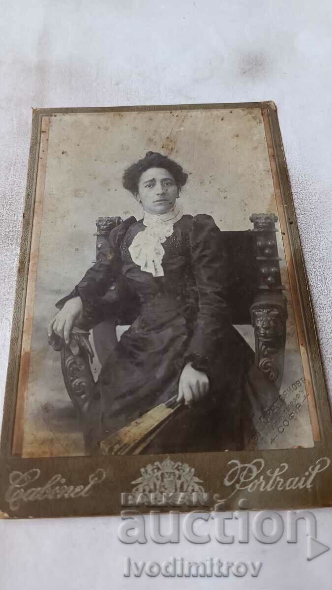 Снимка Жена в черна рокля седнали на стол Картон