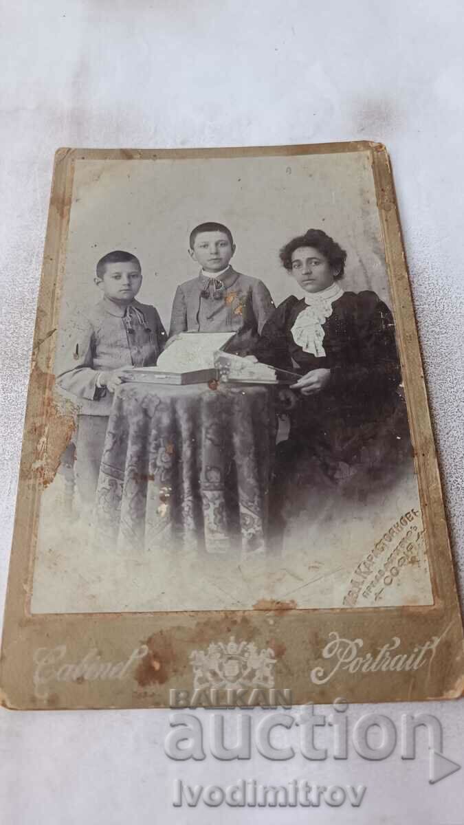 Φωτογραφία Γυναίκα με μαύρο φόρεμα και δύο αγόρια από χαρτόνι