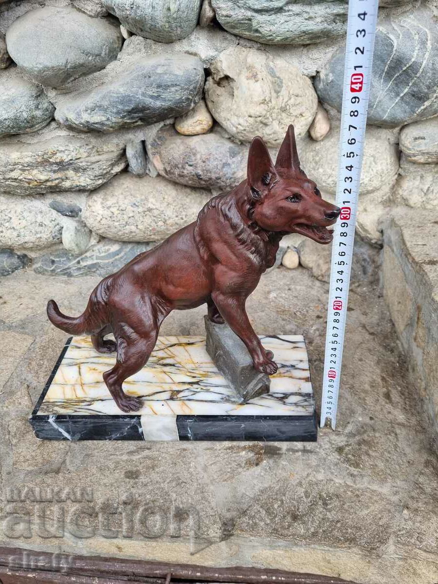 Metal sculpture on marble. Figure of a dog.