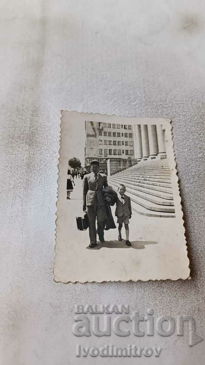 Photo Sofia A man with a suitcase and a boy in front of the Courthouse