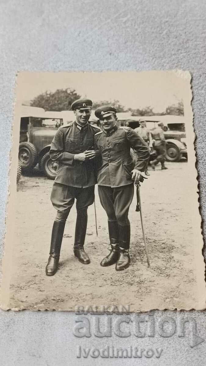 Φωτογραφία Δύο αξιωματικοί μπροστά από vintage στρατιωτικά οχήματα