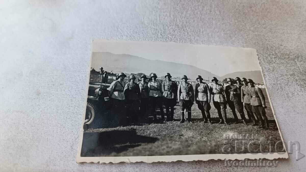 Foto Ofițeri cu cască în fața unui vehicul militar de epocă