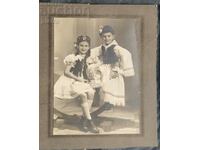 Old photo, cardboard of boy and girl in folk folklore...