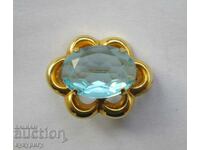 O broșă frumoasă de bătrână elegantă cu o piatră albastru deschis