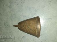 A large old bronze chan bell claps a bell