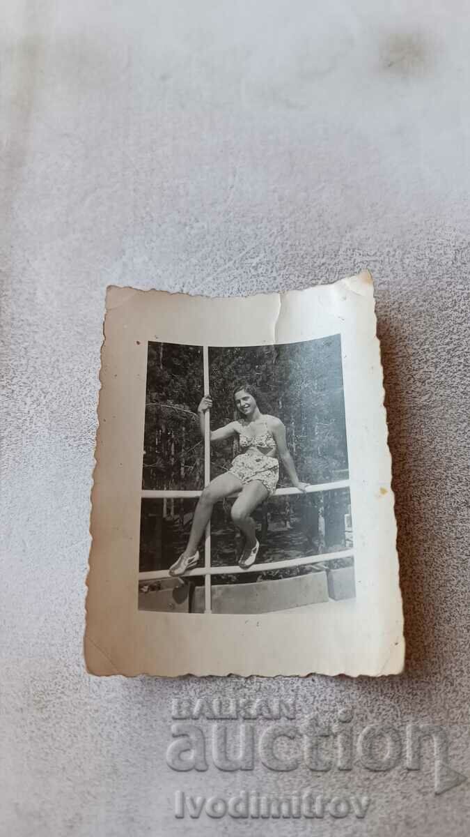 Снимка Младо момиче седнало на парапет