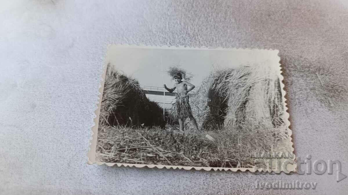 Снимка Момче между две купи със сено