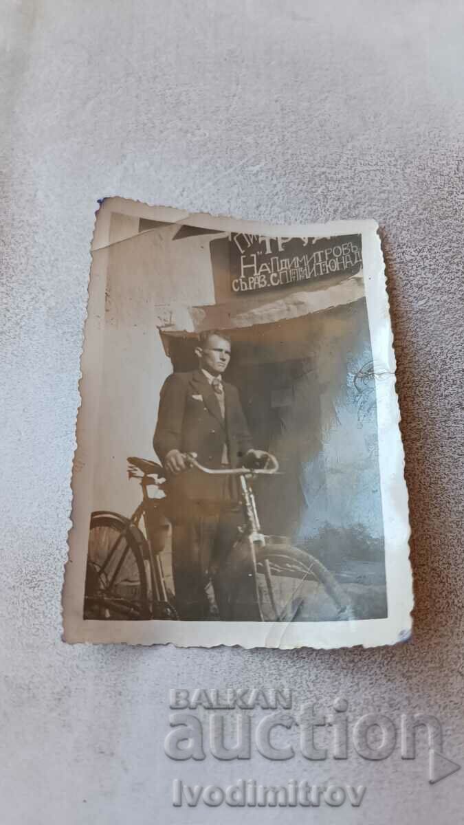 Fotografie Omul lui Bukovets cu o bicicletă de epocă în fața Pivnitsa TRUDO