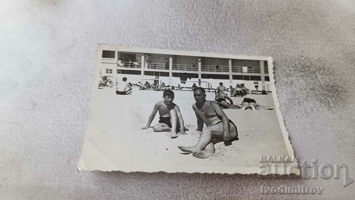 Photo of a man and a boy on the beach
