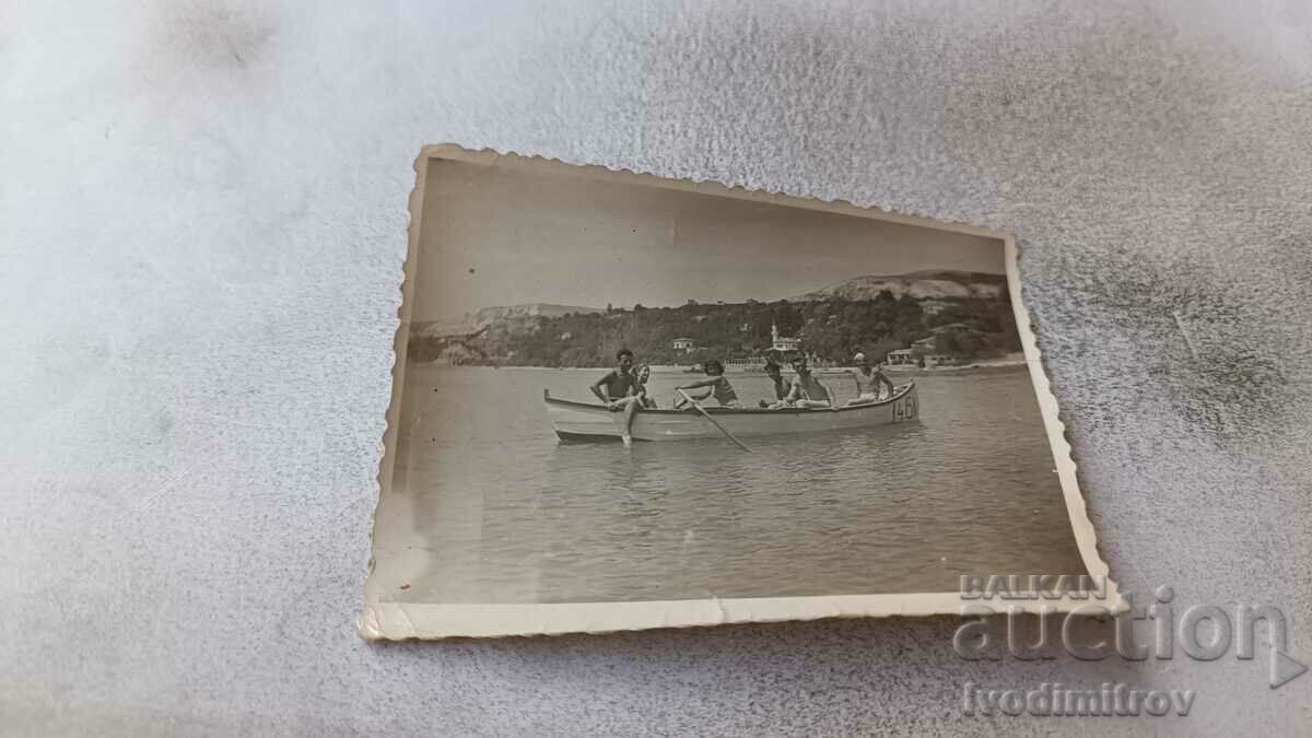 Foto Băieți și fete cu o barcă pentru plimbări în mare