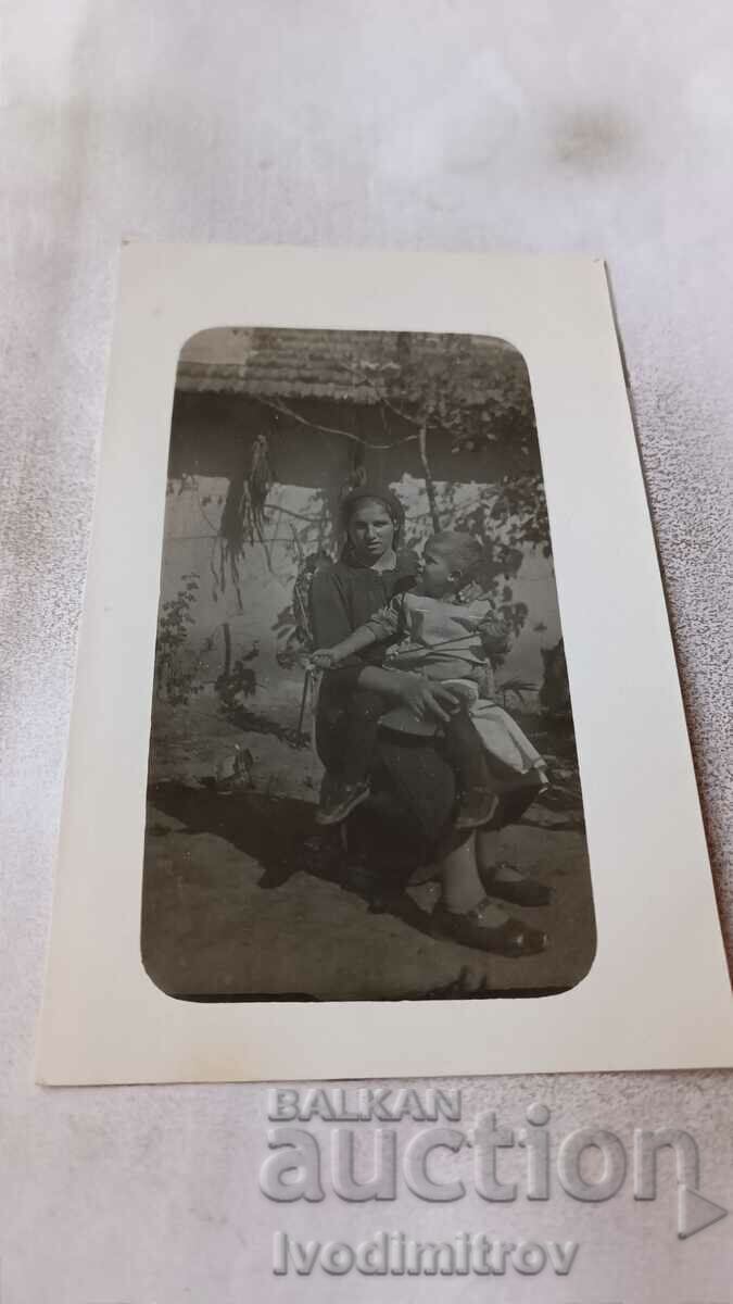 Fotografie Varna O femeie ținând în brațe un băiețel în curtea unei case 1928