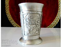 A pewter cup with three romantic paintings.