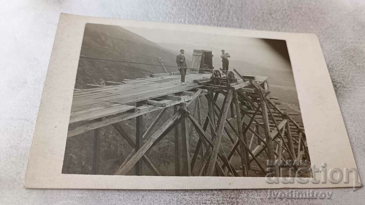 Photo Two men on a wooden elevator structure