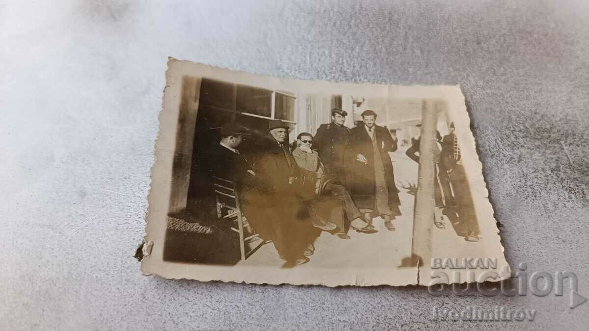 Photo Nervous Officer and men in front of a sidewalk shop 1941