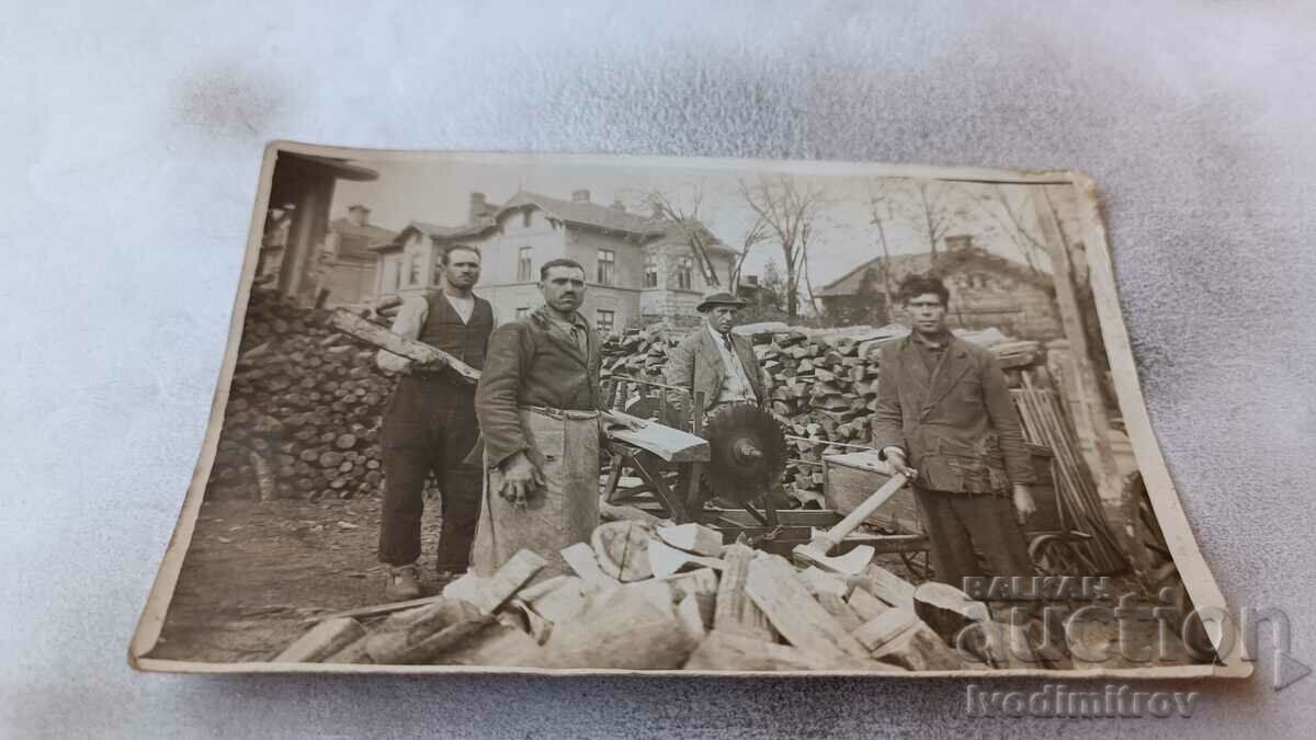 Φωτογραφία Τρεις άνδρες που κόβουν καυσόξυλα με κυκλικό πριόνι