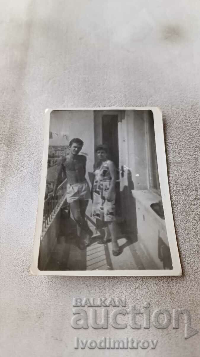 Fotografie O femeie și un bărbat în pantaloni scurți pe un balcon