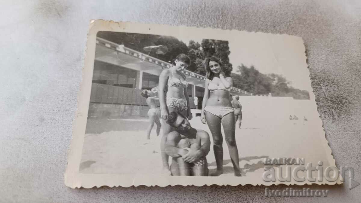 Fotografie Un tânăr și două fete tinere pe plajă