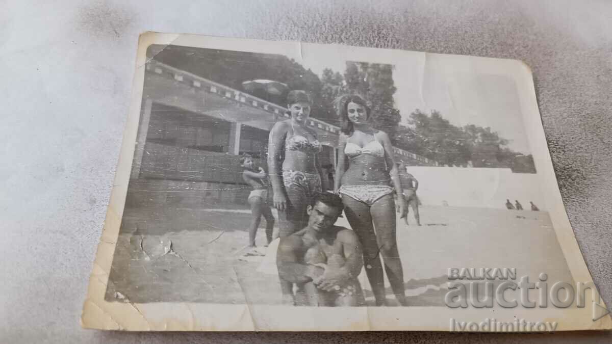 Fotografie Un tânăr și două fete tinere pe plajă