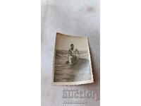 Снимка Мъж седнал на скала в морето